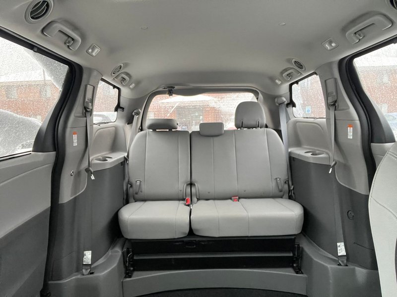 High-quality image of a minivan interior featuring grey leather seats and ample space for passengers.