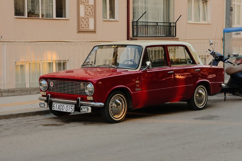 Classic 1960s red car parked on a quiet street in Çankırı, Türkiye, showcasing vintage automotive design.