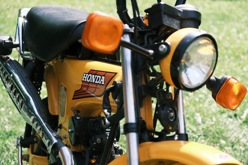 Detailed close-up shot of a vintage Honda motorcycle on a sunny day.