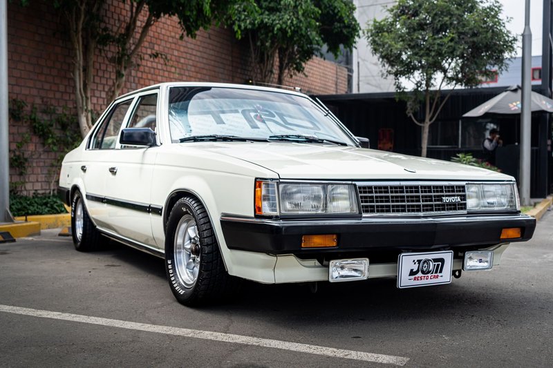 A beautifully preserved classic Toyota Corona T140 parked in an urban environment.
