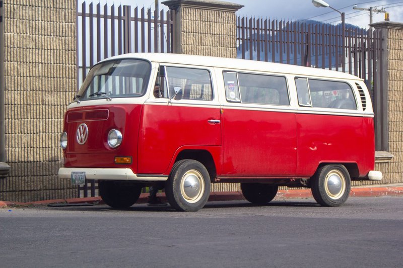 Vintage Volkswagen van parked on an urban street during the day.
