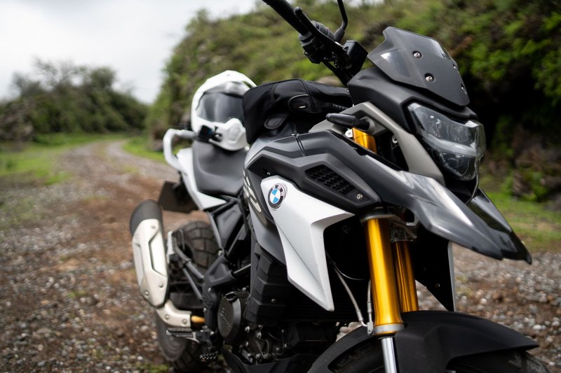 Dynamic shot of a BMW motorcycle positioned on a gravel path outdoors, perfect for adventure enthusiasts.