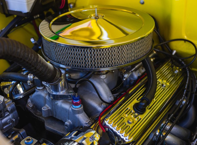 Detailed view of a car engine featuring chrome elements and intricate mechanical parts.