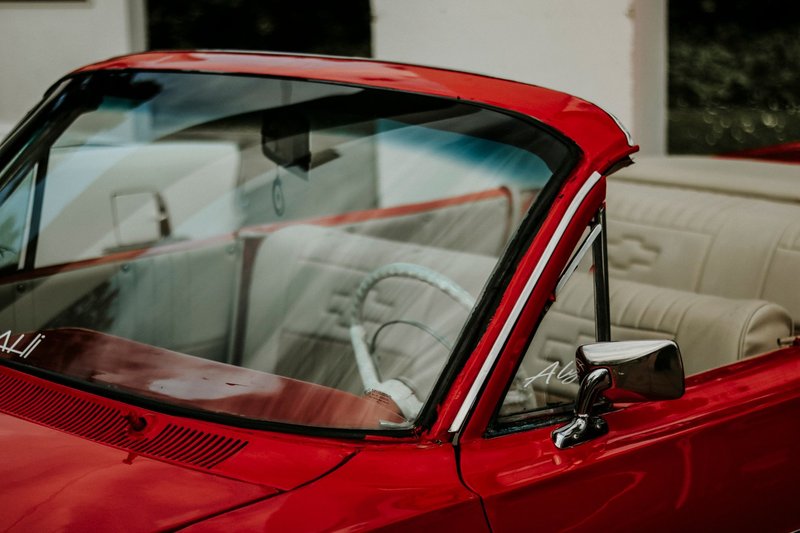 Close-up view of a vintage red convertible with a classic interior style.