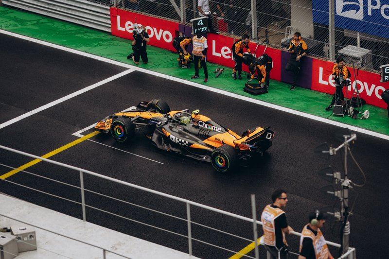 Formula 1 race car in pit stop with crew, showcasing teamwork and speed.