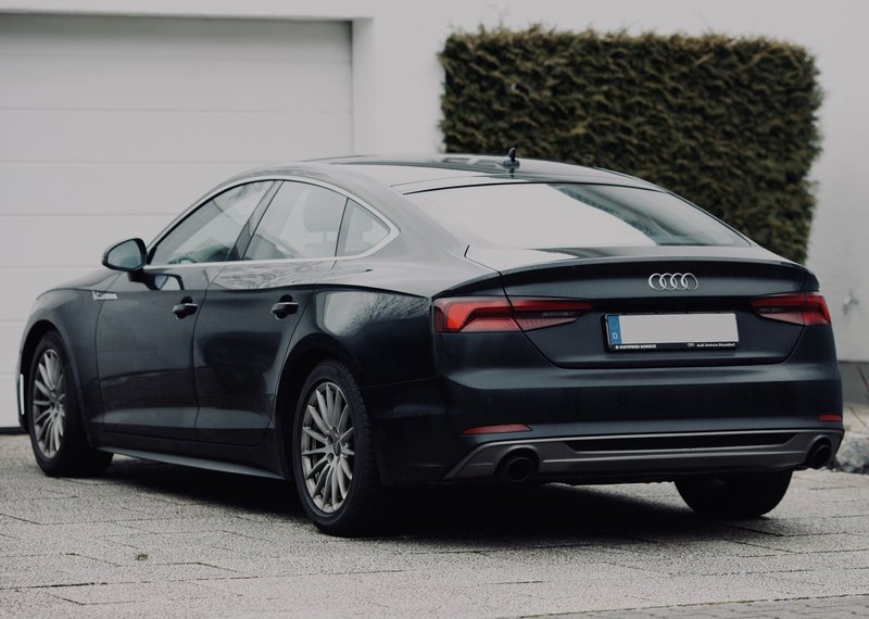 Stylish black sedan parked on a suburban street, highlighting its modern design.