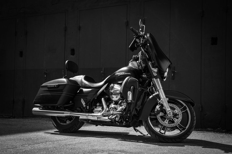 Black Harley-Davidson parked in a moody urban setting, showcasing classic design.