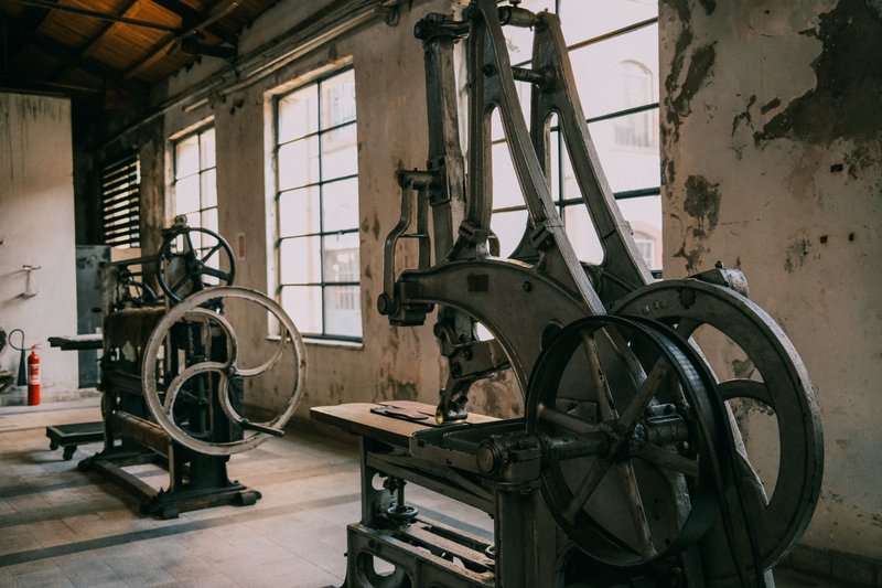 A view of vintage industrial machinery in an abandoned factory setting, emphasizing rustic charm.