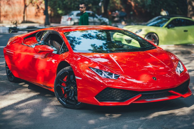 A vibrant red supercar parked outdoors in New Delhi, showcasing luxury and modern design.