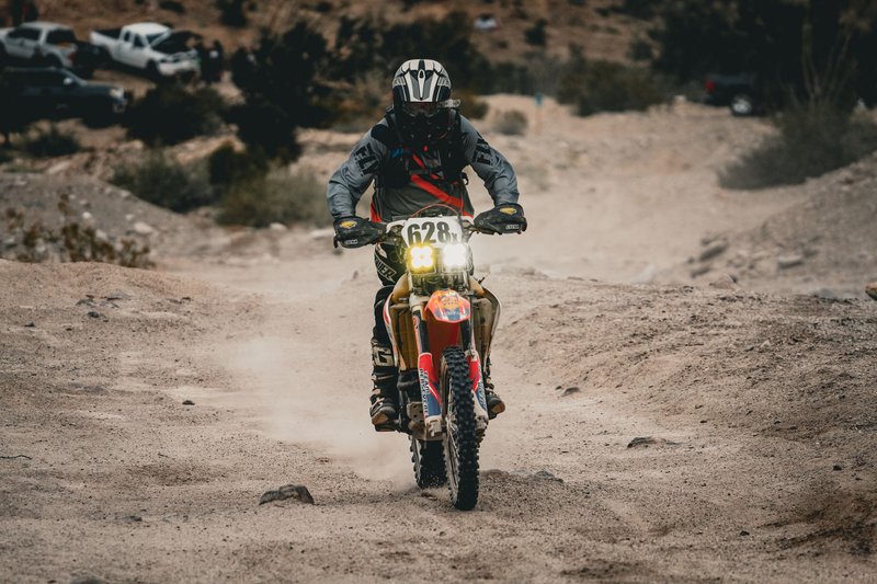 Rider on a motorcycle offroading through Mexicali desert terrain, showcasing adventure.
