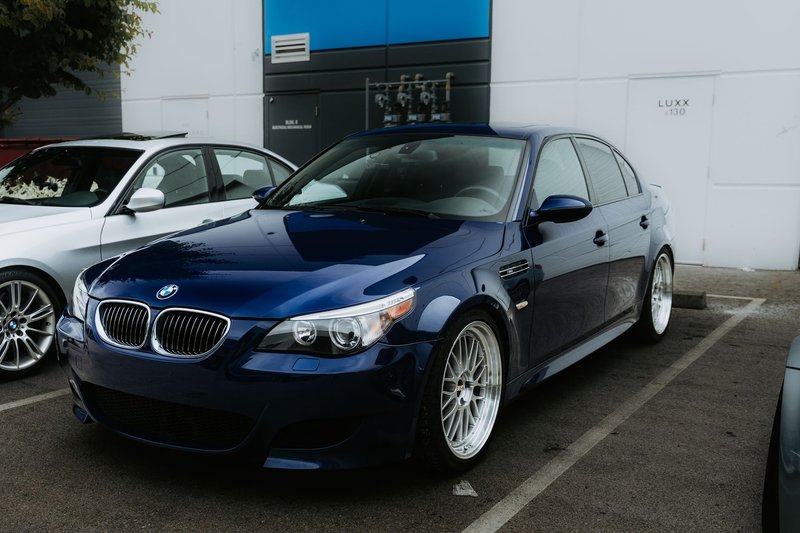 A stylish blue luxury sedan parked in an urban setting, showcasing high-end automotive design.