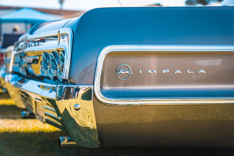 Detailed view of a classic Chevrolet Impala tail end showcasing emblem and chrome details.