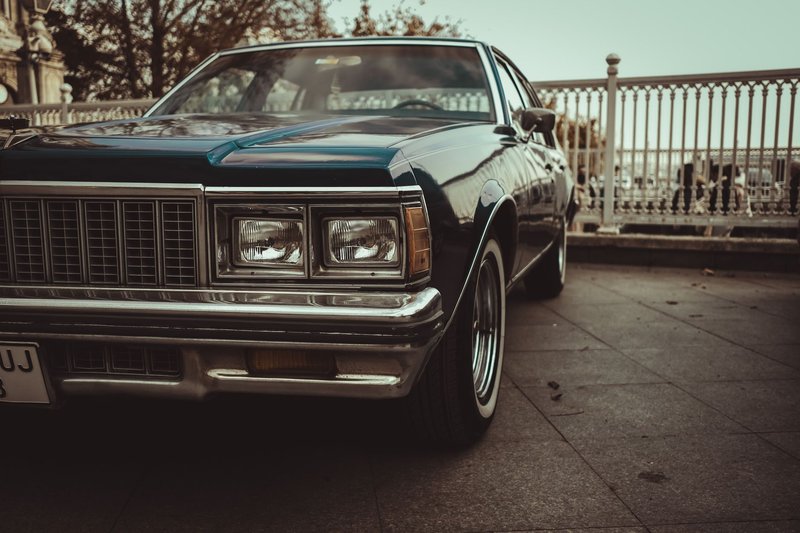 Close-up of a vintage Chevrolet Caprice car parked outdoors, showcasing a retro headlight design.