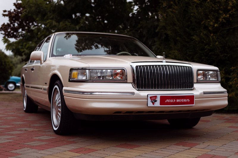 Vintage Lincoln Town Car with chrome details parked outdoors on a paved area.