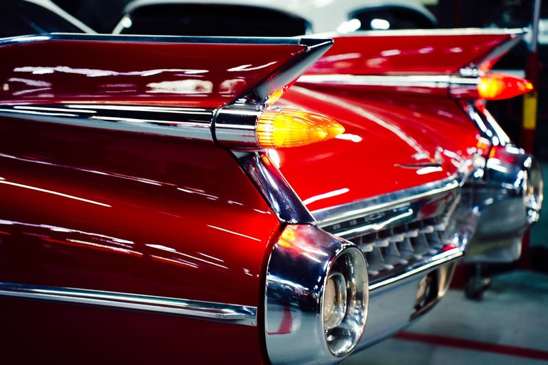 Detailed image of bright red classic Cadillac tailfins highlighting vintage automotive design.