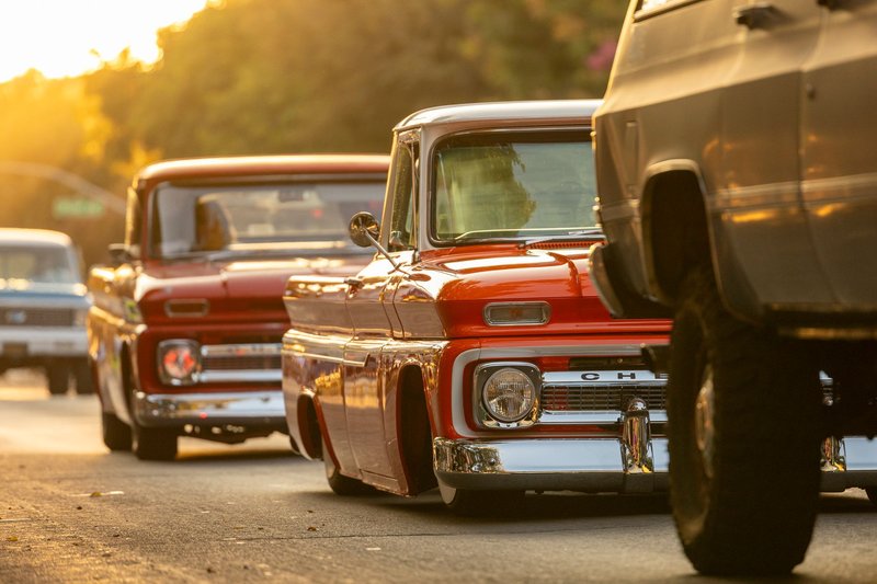 Retro Chevrolet trucks showcased on city streets during a golden sunset, highlighting vintage automotive design.