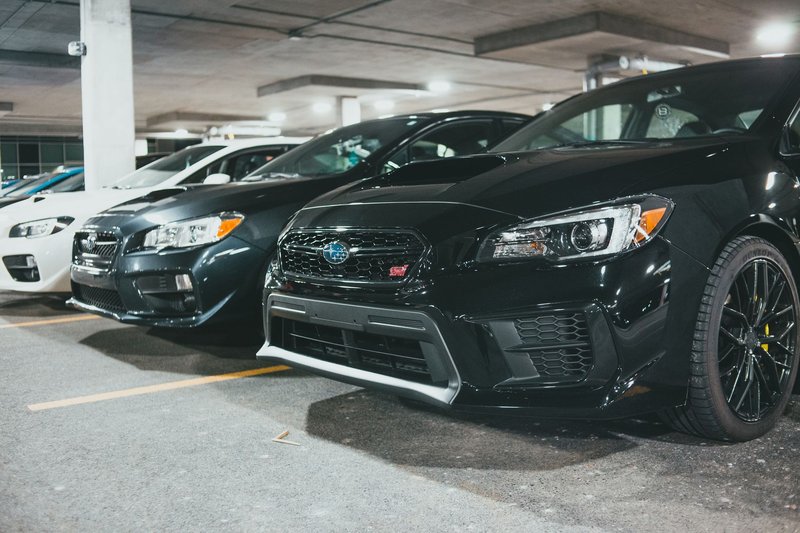 A row of parked Subaru cars in an indoor parking garage, showcasing modern automotive design.