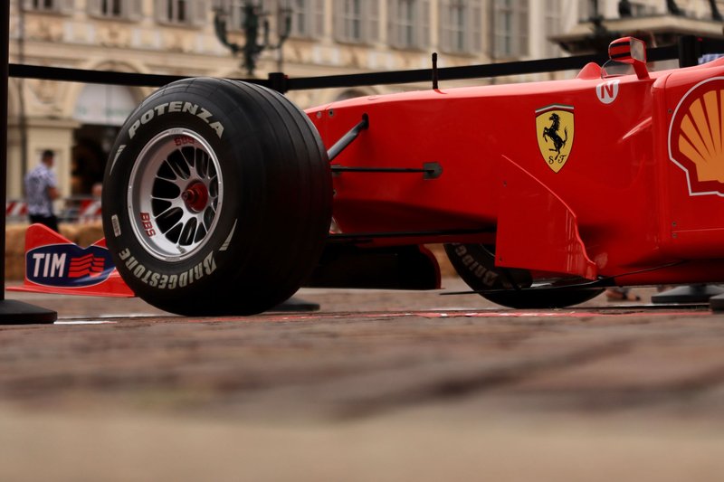 Close-up shot of a red Formula 1 racing car with visible brand logos and Bridgestone tire.