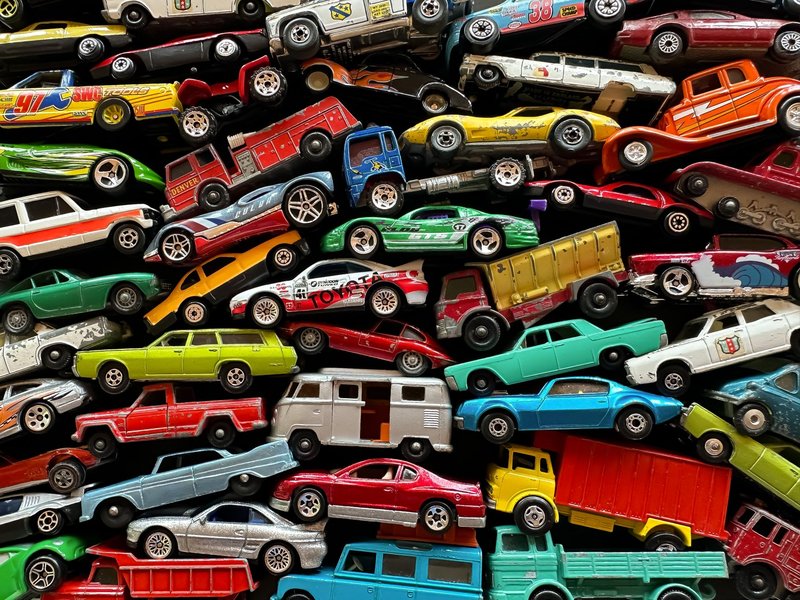 An organized assortment of miniature toy cars displayed in a vibrant and colorful arrangement.