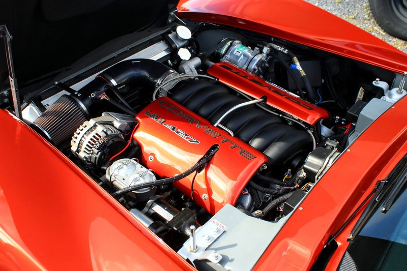 Close-up of a powerful Corvette engine with red accents, showcasing automotive engineering.