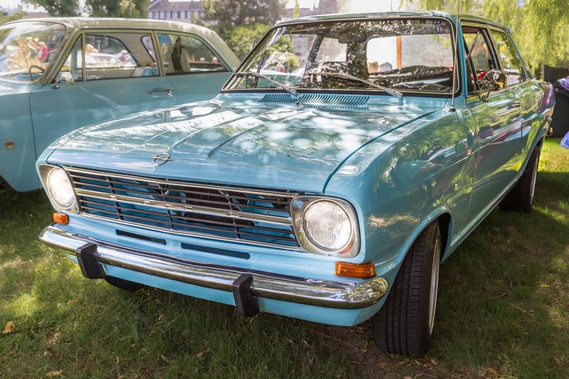 Classic blue Opel oldtimer displayed at an outdoor car show on a sunny day.