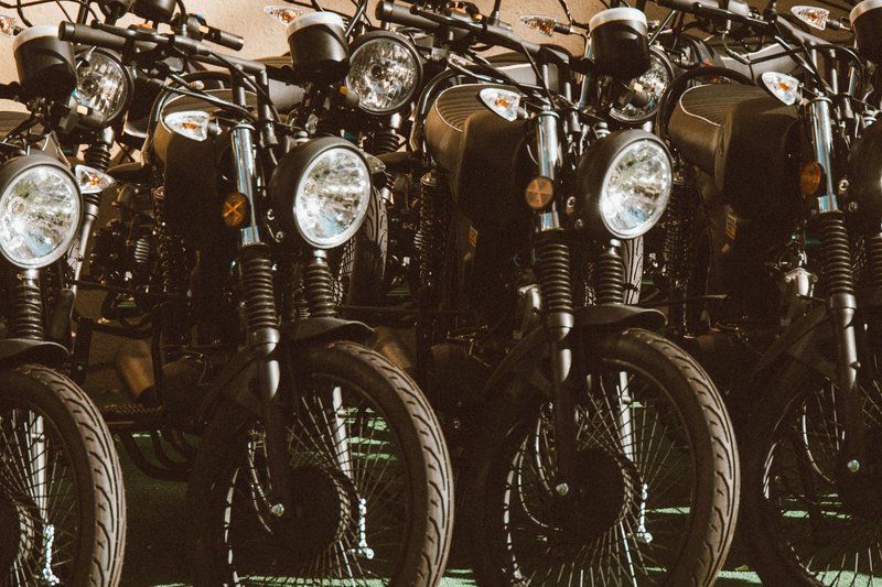 A stylish lineup of vintage motorcycles parked in a sunlit outdoor setting.
