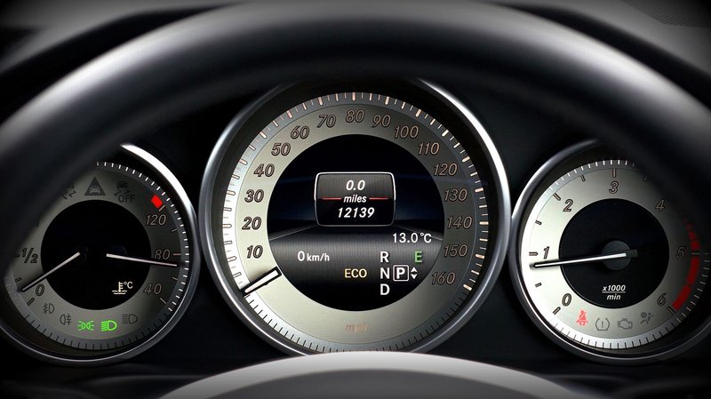 Close-up image of a car dashboard highlighting speedometer, odometer, and temperature gauge.