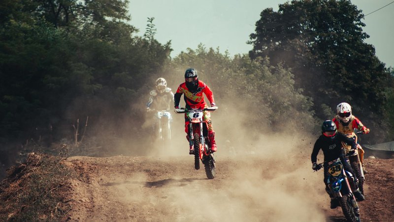 Action-packed motocross race with riders speeding through a dusty track, showcasing excitement and competition.