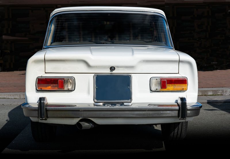 Rear view of a classic white Alfa Romeo Giulia TI Super parked outdoors.