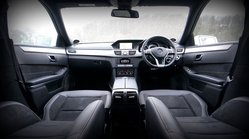 Explore the luxurious interior of a modern car featuring a sleek dashboard and leather seats.