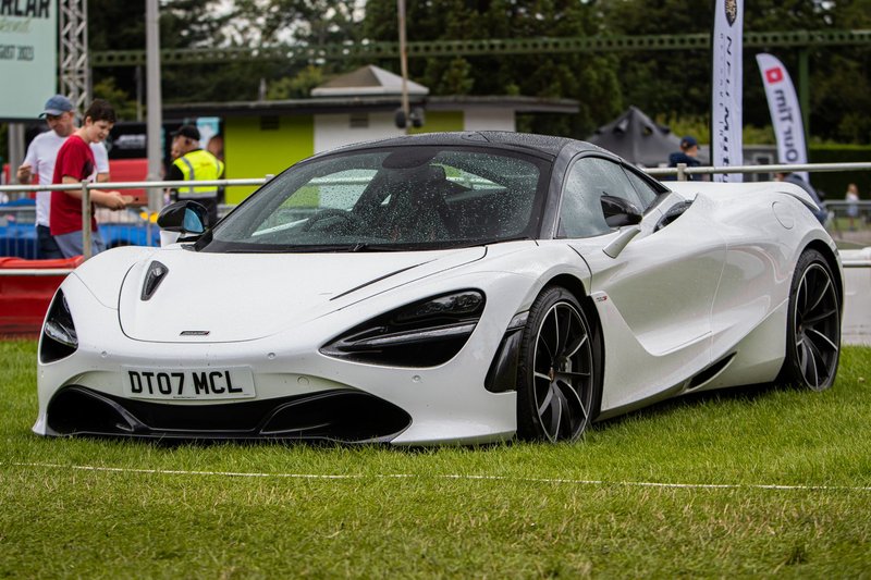 Stunning white McLaren 720S supercar displayed outdoors at an auto event.