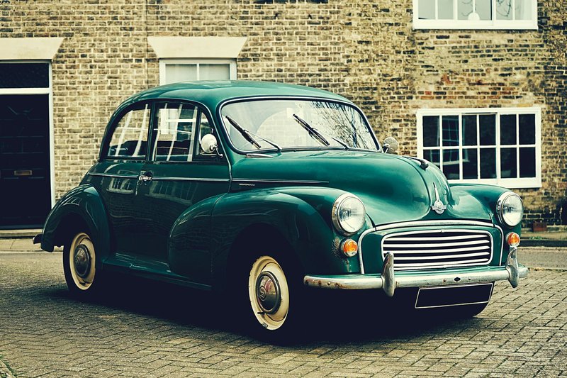 A classic Morris Minor parked outside a brick building in Ely, UK. Vintage charm captured outdoors.
