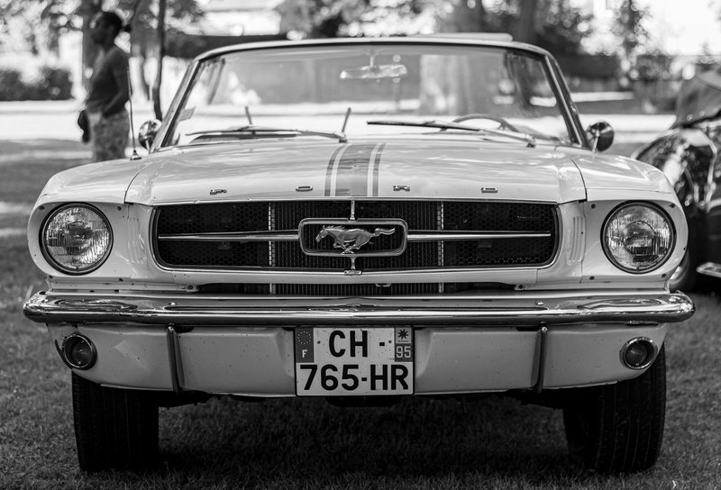 Vintage Ford Mustang in black and white, highlighting its retro style and classic design.