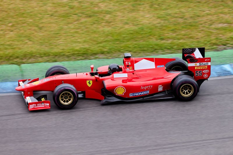 High-speed Formula 1 car in action on an outdoor racing track, showcasing motion and excitement.