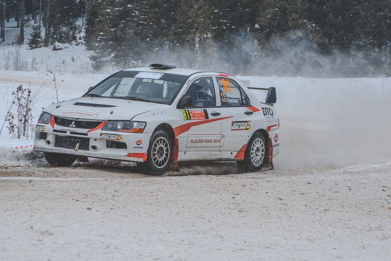 Mitsubishi rally car in action drifting on snowy roads in Comandău, Romania.
