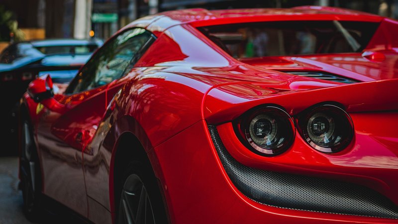 Close-up shot of a luxurious red sports car showcasing its sleek design and shiny surface.