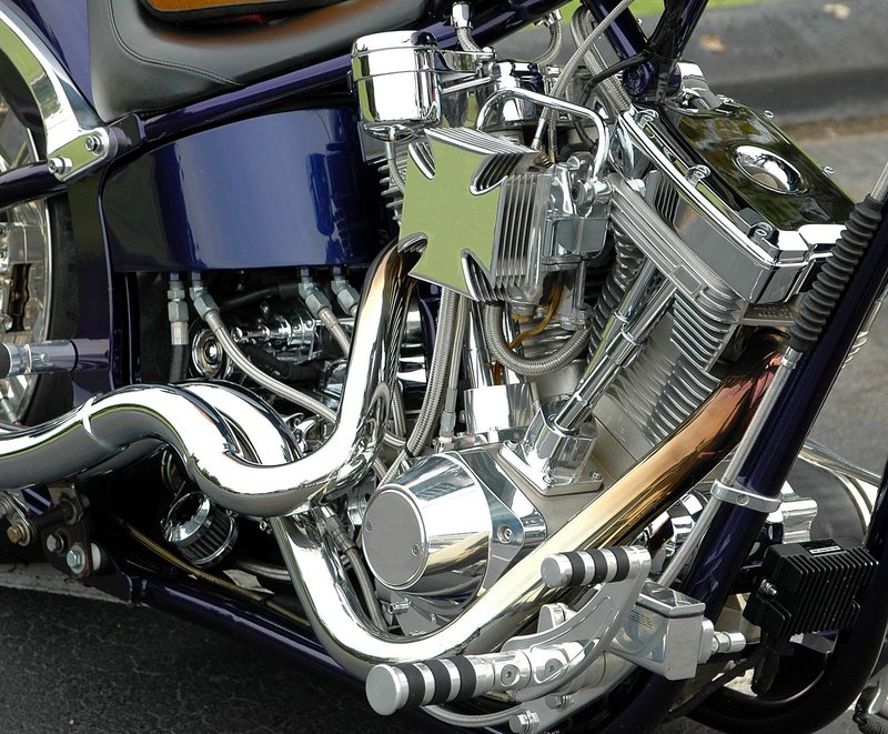 Detailed view of a polished chrome motorcycle engine with a custom cross emblem.