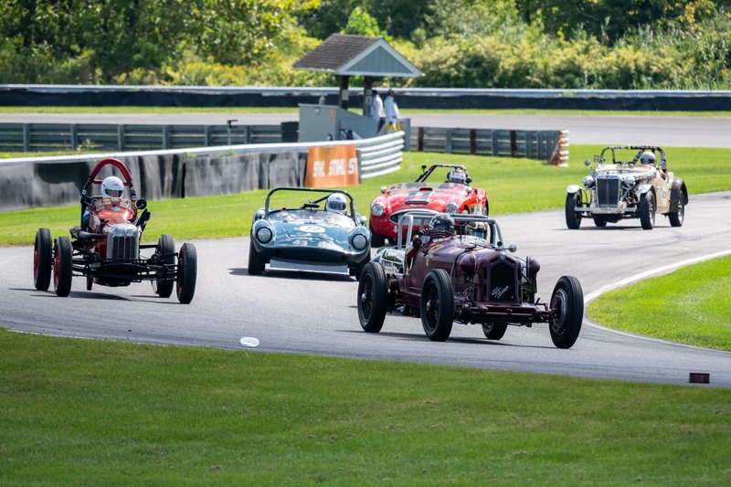 Historic car race on an outdoor track in Salisbury, Connecticut, featuring vintage sports cars in action.