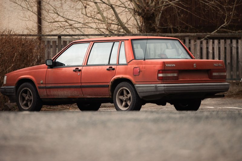 A classic red Volvo 740 GL car parked outdoors in winter, highlighting vintage automotive design in a Swedish setting.
